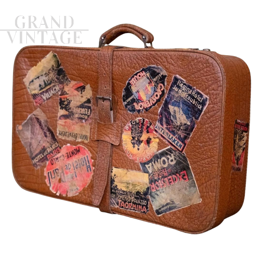 Valigia in cuoio vintage con adesivi di viaggio                            