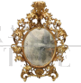 Importante specchio ovale antico a cartoccio in legno intagliato e dorato, XVIII secolo                            