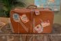 Valigia in cuoio vintage con adesivi di viaggio                            