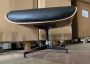 Poltrona lounge di Charles Eames con pouf, in pelle nera goffrata e palissandro
