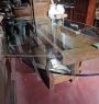 Tavolo da salotto industriale composto da un banco da falegname con piano in vetro