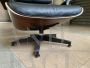 Poltrona lounge di Charles Eames con pouf, in pelle nera goffrata e palissandro