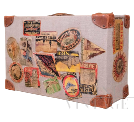Valigia vintage in tessuto beige e cuoio marrone con adesivi di viaggio                            