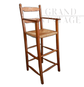 Vintage high chair with straw seat and armrests