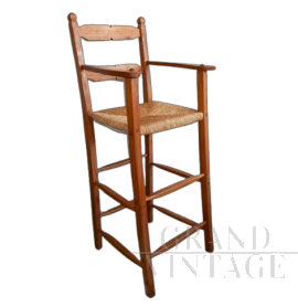 Vintage high chair with straw seat and armrests