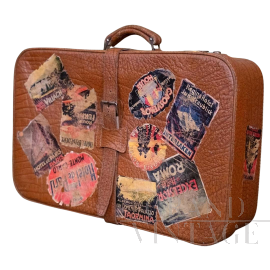 Valigia in cuoio vintage con adesivi di viaggio                            