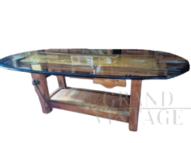 Tavolo da salotto industriale composto da un banco da falegname con piano in vetro                            