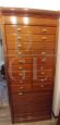 Vintage wooden filing cabinet with drawers and roller shutter at the base                            