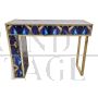 Asymmetric design console in backlit blue and gold glass