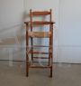 Vintage high chair with straw seat and armrests