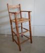 Vintage high chair with straw seat and armrests