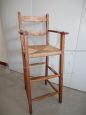 Vintage high chair with straw seat and armrests