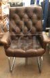 Directional vintage armchair in capitonné leather
