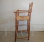Vintage high chair with straw seat and armrests