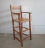 Vintage high chair with straw seat and armrests