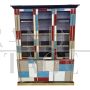 Large bookcase covered in colored glass and illuminated 