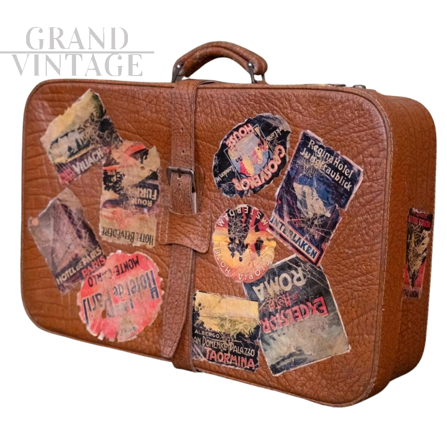 Valigia in cuoio vintage con adesivi di viaggio                            