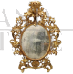 Importante specchio ovale antico a cartoccio in legno intagliato e dorato, XVIII secolo