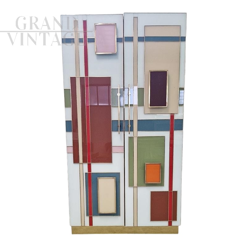 Wardrobe or pantry cabinet in colored glass with illuminated mirror interior  